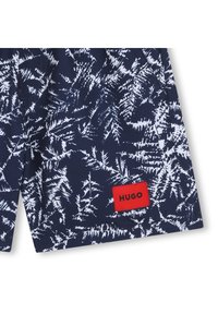 Σκούρο μπλε σορτς με λευκό σχέδιο φυλλώματος, με κόκκινο λογότυπο "HUGO". Κατασκευασμένα από μαλακό ύφασμα με ελαστική μέση.