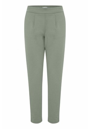 Pantaloni tapered de culoare verde deschis, confecționați dintr-un material moale, având o talie elastică și două pliuri frontale pentru un plus de detaliu în design.