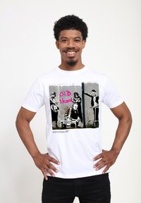Bílý bavlněný tričko s grafickým potiskem čtyř postav na šedém pozadí, s nápisem "OLD skool" v růžovém textu.