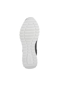 Chaussure de sport noire avec une semelle en caoutchouc blanche, présentant un motif de semelle texturé et un détail de marque sur le côté.
