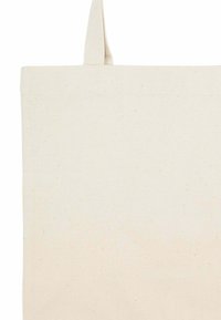 Canvas draagtas in off-white met stevige handgrepen. Glad oppervlak, ruime ontwerp en minimalistische esthetiek zonder zichtbare patronen.