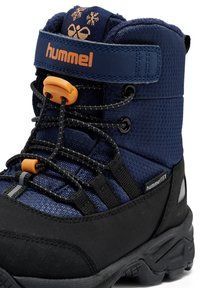 Marinblå och svart vinterkänga med en texturerad övre del, orangea detaljer, elastiskt snörsystem och snöflinge-design på ankelremmen.