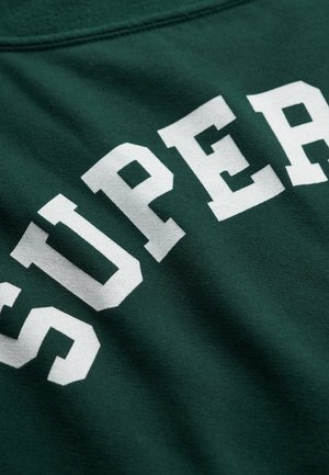 Groen stof met dikke witte hoofdletters die "SUPER" spellen in een gebogen opstelling.