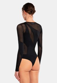 Musta bodysuit, jossa on pitkät läpinäkyvät verkkohihat, avonainen selkäosa ja paneeliyksityiskohtia. Kangas on sileää ja joustavaa.