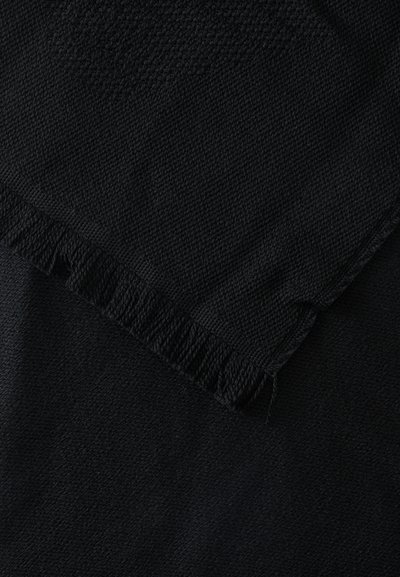 Tissu noir tissé avec un bord plié montrant un tricot texturé et un détail de franges sur un côté.