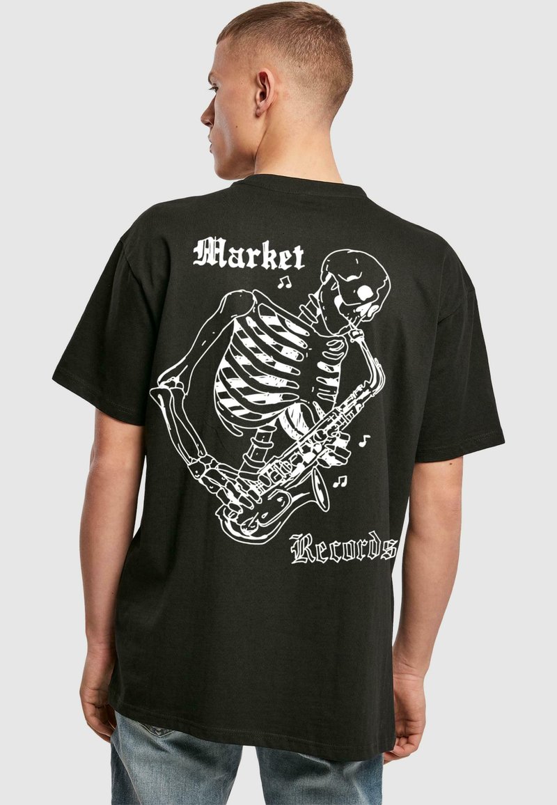 Must must hele musta, millel on valge luustikukujutis, mis mängib saksofoni, ning tekst "Market" ja "Records". Lühikesed varrukad, vabalt istuv.