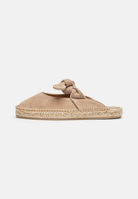Beige ruskind slip-on sko med en knyttet overdel, jute-indpakket sål og et fladt design, der har en glat tekstur og enkle linjer.