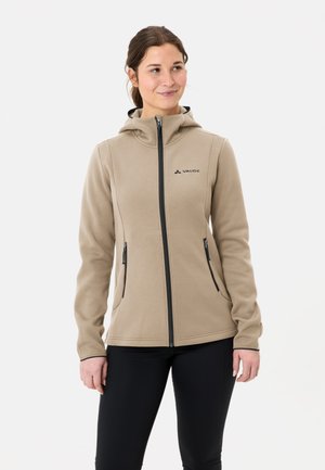 Veste en polaire beige avec capuche, fermeture éclair à l'avant et deux poches latérales. Présente des accents de fermeture éclair noirs et un petit logo sur la poitrine.