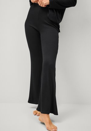 Zwarte geribde flared broek met een hoge tailleband en een soepele textuur, die tot aan de enkels reikt met een lichte flare aan de zoom.