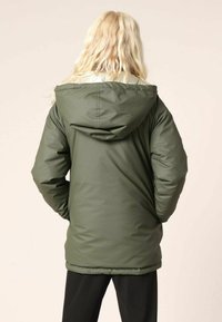 Veste isolante vert olive avec capuche, présentant une texture lisse et des poignets élastiques. La vue arrière montre un design simple sans embellissements.