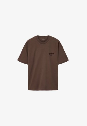 Bruine katoenen T-shirt met een ronde hals, korte mouwen en een zwarte logo-afdruk op de bovenste linkerzijde. Gladde textuur, ontspannen pasvorm.