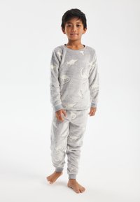 Gray, fuzzy pajama set featuring white dinosaur patterns, with a long-sleeve top and elastic waistband bottoms.
