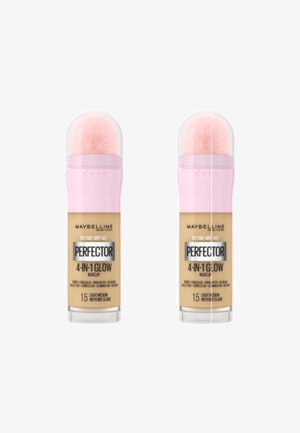Maybelline Perfecter 4-en-1 Glow maquillage, deux contenants cylindriques avec un capuchon rose pâle, présentant une teinte claire à moyenne et un applicateur à double fonction.