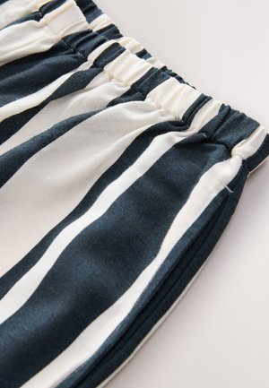 Tessuto a righe blu navy e crema con una cintura elastica. Texture morbida, finitura liscia e design a vestibilità rilassata.