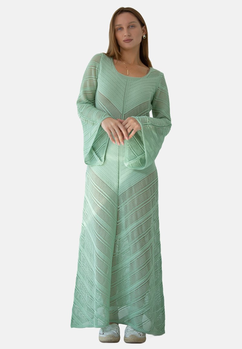 Miętowa, długa sukienka z długimi rękawami i teksturowanym, zygzakowym wzorem. Posiada rozszerzane rękawy i dopasowaną sylwetkę, wykonana z dzianiny.