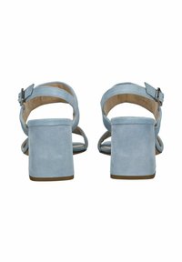 Sandalias de tacón cuadrado de gamuza azul claro con correas ajustables en el tobillo y parte trasera abierta, con una textura suave y un diseño minimalista.