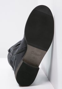 Botín de ante negro con cremallera lateral, suela con la marca "Gabor", talla 4½ y marcado "Hecho en Portugal".