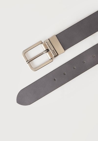 Ceinture en cuir gris foncé avec une boucle rectangulaire en métal argenté gravée de "Karl Lagerfeld Paris" sur un fond clair uni.