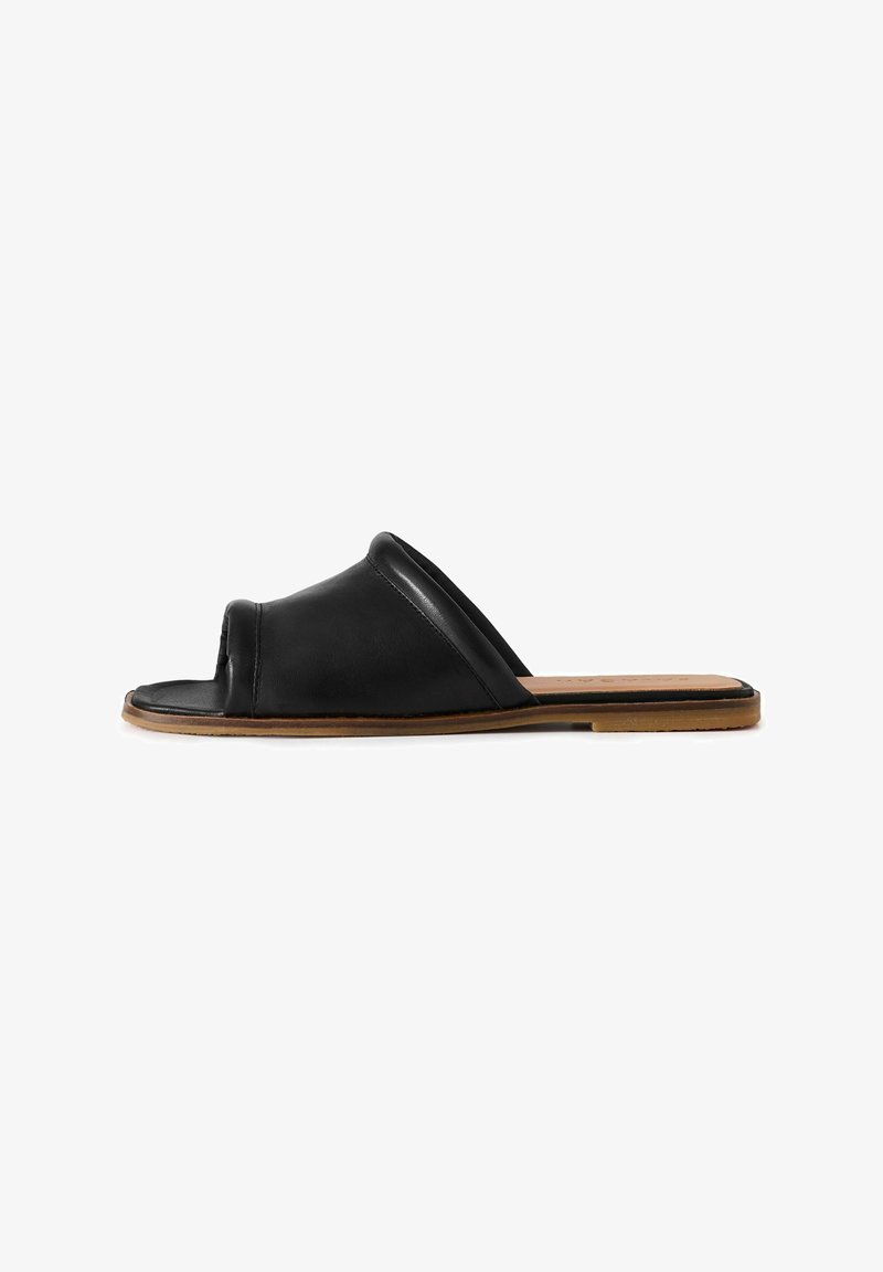 Zwarte leren slip-on sandaal met een open teen, een zacht textuur bovenwerk, een gebogen silhouet en een platte tankleurige zool.