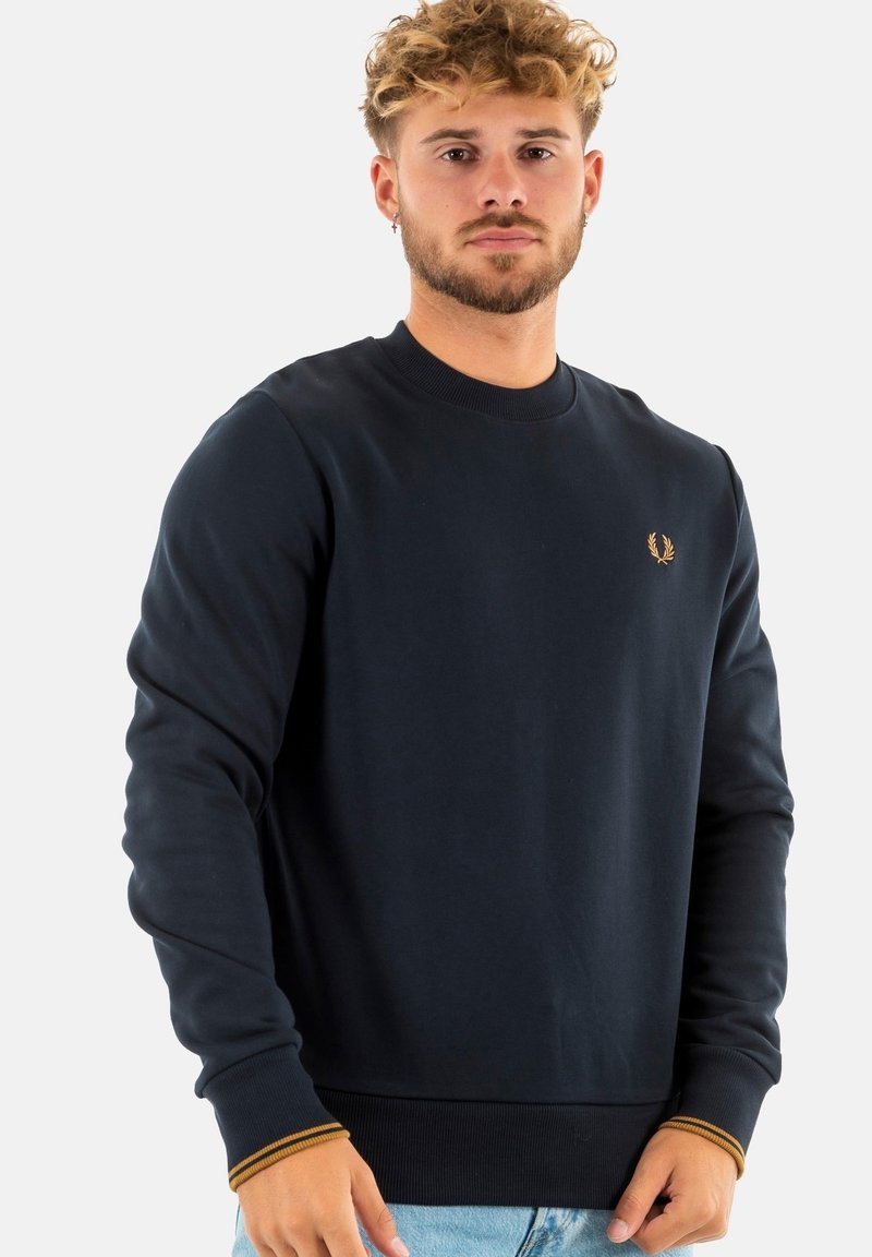 Sudadera de cuello redondo en color marino con puños y dobladillo acanalados, que presenta un detalle de logo dorado en el lado izquierdo del pecho y una tela suave y texturizada.