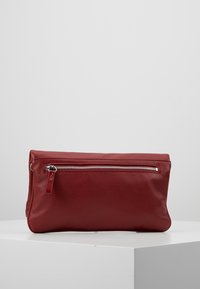 Červená kožená psaníčko s texturovaným povrchem a stříbrným zipem na přední straně. Plochý obdélníkový tvar, minimalistický design.