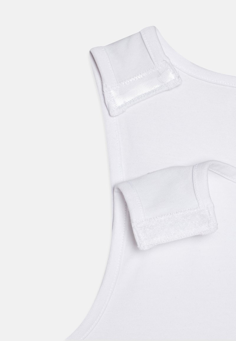 Débardeur blanc en tissu doux, avec encolure arrondie et bretelles auto-agrippantes pour un ajustement réglable. Sans motifs ni accents supplémentaires.