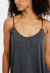Har gray tank top dengan leher v, tali kepang, dan empat kancing emas di bagian depan. Memiliki tekstur halus dengan potongan santai.