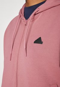 adidas Sportswear FUTURE ICONS THREE STRIPES FULL ZIP - Camisola com fecho - preloved crimson