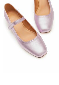 Kvadratiska ballerina-skor i glänsande lavendelfärgad läder med läderfoder. Har ett delikat band över vristen. Platt sula.