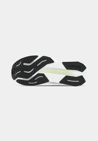 Semelle de chaussure avec une base principalement blanche, dotée d'une semelle extérieure en caoutchouc noir avec des motifs de grip texturés et une subtile ligne d'accent jaune.