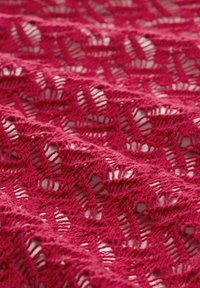 Fuchsia gebreide kantstof met een geometrisch patroon van open en gesloten steken, met een zachte textuur en fijne details.