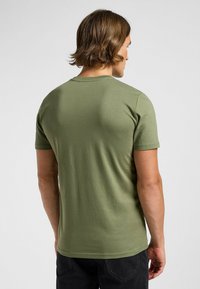 T-Shirt w kolorze oliwkowym, wykonany z miękkiego materiału, z okrągłym dekoltem i krótkimi rękawami, widoczny z tyłu. Prosty, nieozdobiony design.