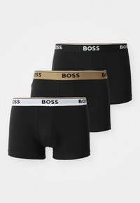 Drei Paar Boxershorts in Schwarz mit elastischen Taillengummis in Schwarz, Weiß und Gold mit "BOSS"-Branding. Glatte Stofftextur.