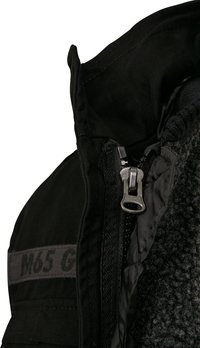 Zwarte jas met een rits en fleece voering. Voorzien van het M65 G-logo, stevig materiaal en een hoge kraag voor extra bescherming.