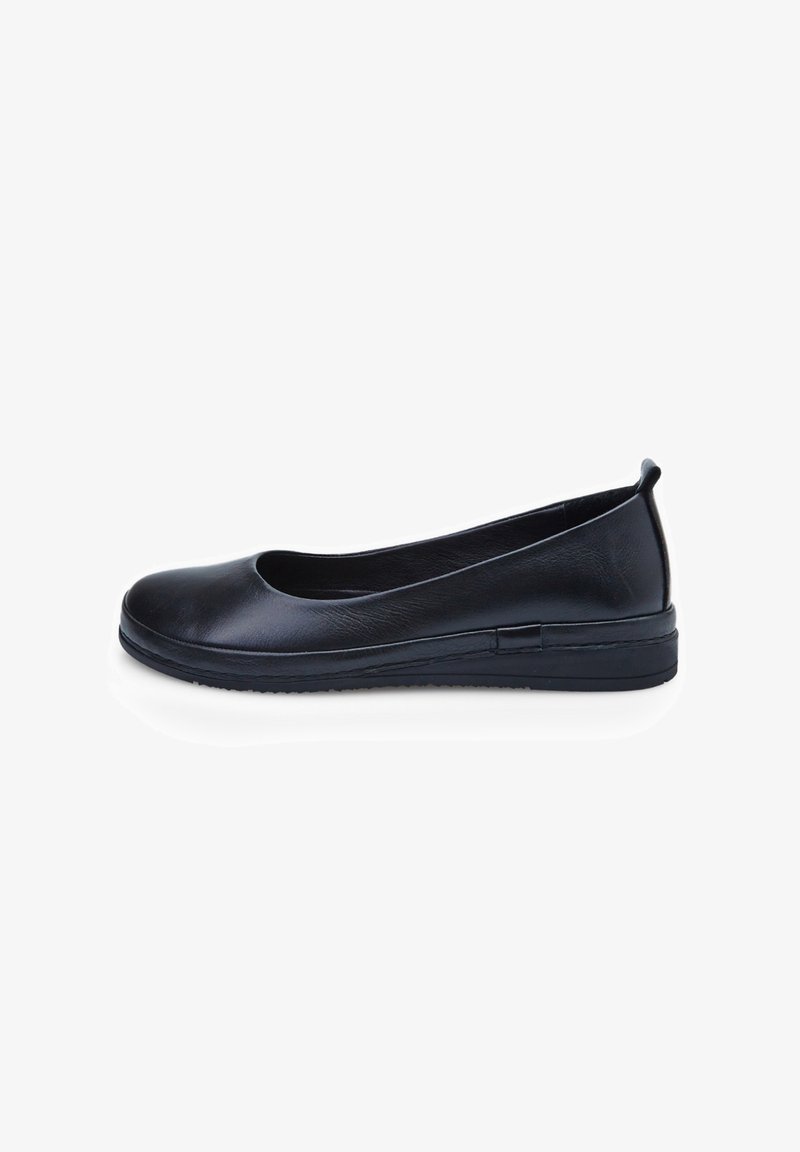 Chaussure plate en cuir noir avec bout arrondi, semelle basse et languette au talon, vue de côté sur fond blanc.