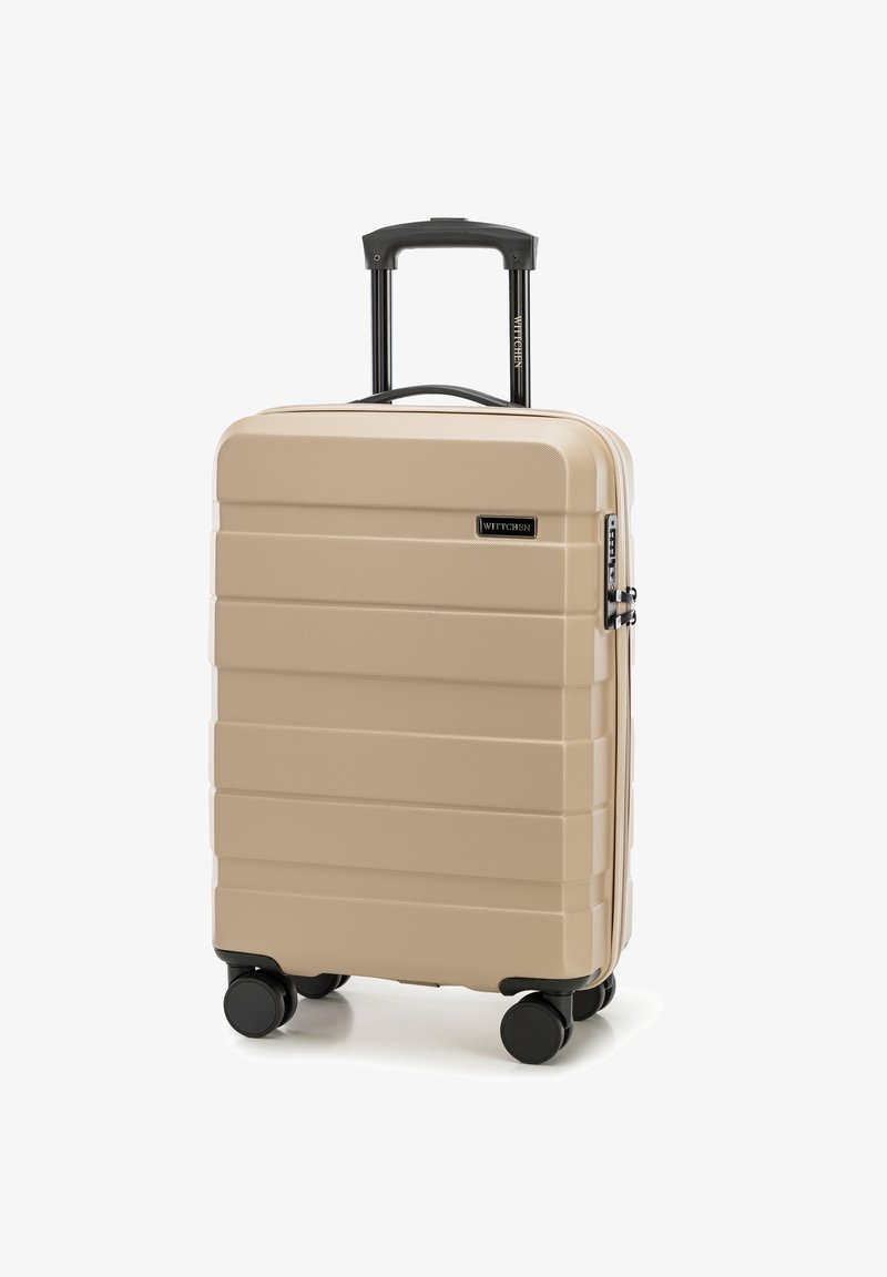 Valigia rigida beige con finitura texturizzata, dotata di manico retrattile, quattro ruote nere e una serratura a combinazione.