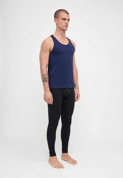 Marineblå tank topp kombinert med svarte leggings. Toppen er ermeløs med rund hals; leggingsene har en tettsittende design og ankel-lange mansjetter.