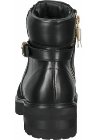 Bottine en cuir noir avec col rembourré, fermeture éclair latérale, sangle à boucle et semelle épaisse crantée vue de dos.