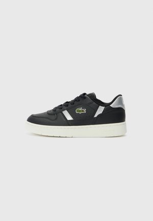 Czarny niskoprofilowy sneaker z białą podeszwą, srebrnymi akcentami, czarnymi sznurowadłami i zielonym logo krokodyla na boku, prezentowany na jednolitym tle.