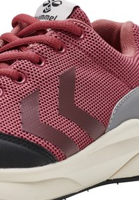 Sport sneakers med överdel i mörkrosa nätmaterial, med grå detaljer, en svart tåskydd och två stiliserade ränder i en mörkare nyans av rosa.
