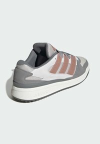 Gray athletic sneaker with mesh and suede materials, featuring three pink stripes, a white midsole, and a textured rubber outsole.