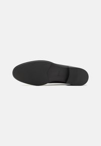 Black leather shoe sole with a smooth surface, minimal tread pattern, and "BOSS" branding on the side. Rounded shape, durable design.