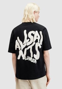 Tricou din bumbac negru, prezentând un grafic mare, alb și ondulat care scrie "ALLSAINTS LONDON" pe spate. Mâneci scurte și croială lejeră.