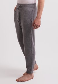 Graue, weiche Jogginghosen aus Baumwollmischung mit elastischem Bund, Kordelzug und zwei Seitentaschen, die zum Knöchel hin zulaufen.