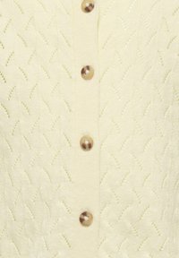 Jasnożółty sweter z dzianiny z teksturowanym wzorem, okrągłymi brązowymi guzikami i zapięciem na guziki z przodu.