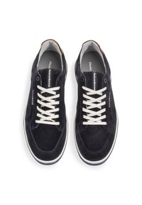 Marina mockasiner i mocka med vita snören och en brun läderdetalj vid hälen. Har en rund tå och kontrasterande sömmar. Slät innersula.