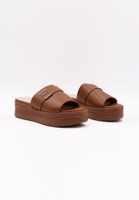 Bruine leren slidersandalen met open teen, voorzien van een gevoerd bandje en een gestructureerde platte zool die lijkt op gevlochten jute.