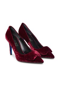 Red velvet high-heeled pumps with pointed toes, floral embossed pattern, and contrasting blue heel accents. Featuring a ruffled detail on the front.
