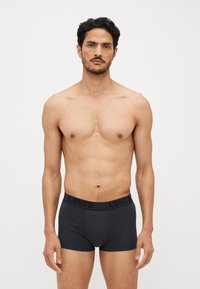 Črne Levi's bokserice z mehkimi elastičnimi pasom, na katerem je napis blagovne znamke, s prilegajočim krojem in gladko teksturo tkanine.