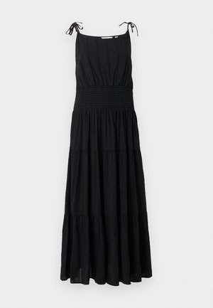 Black sleeveless maxi dress with adjustable tie straps, smocked waist, and tiered flowing skirt.